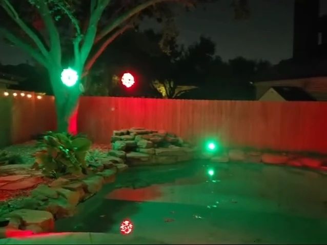 Backyard pool with red and green holiday lighting